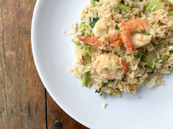 Delicioso arroz frito con camarones en plato blanco sobre mesa de madera. Comida tailandesa . —  Fotos de Stock