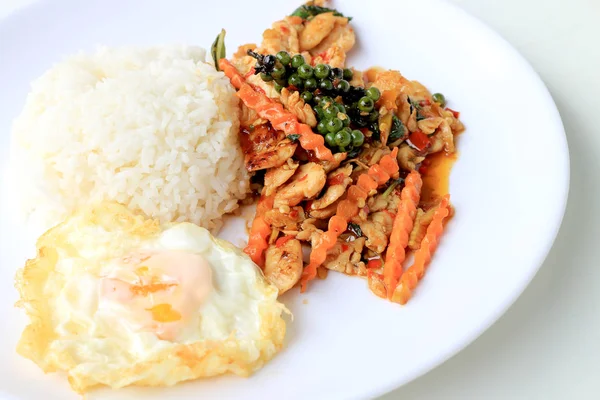 Yasemin pirinç beyaz arka plan üzerinde beyaz tabak içinde kavrulmuş chili Yapıştır ve taze Piper nigrum kızarmış tavuk karıştırın. Tay tarzında gıda.