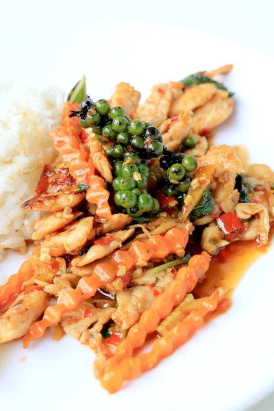 Yasemin pirinç beyaz arka plan üzerinde beyaz tabak içinde kavrulmuş chili Yapıştır ve taze Piper nigrum kızarmış tavuk karıştırın. Tay tarzında gıda.