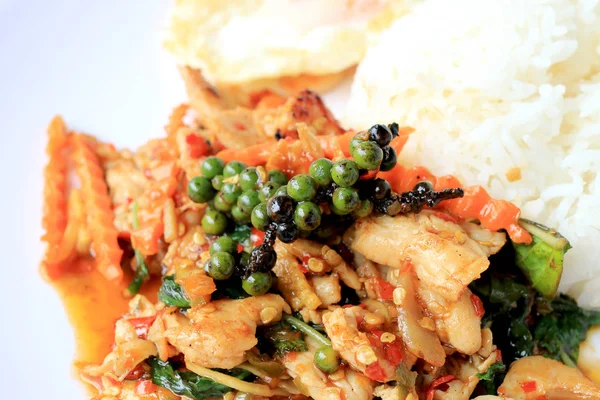 Yasemin pirinç beyaz arka plan üzerinde beyaz tabak içinde kavrulmuş chili Yapıştır ve taze Piper nigrum kızarmış tavuk karıştırın. Tay tarzında gıda.