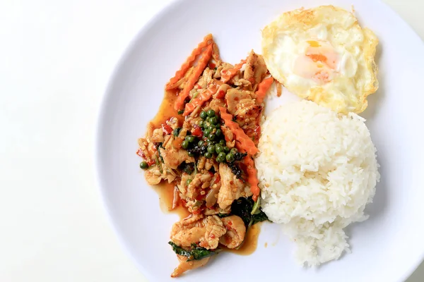 Mezcle el pollo frito con pasta de chile asado y el Piper nigrum fresco sobre el arroz jazmín en un plato blanco sobre fondo blanco. Comida tailandesa . — Foto de Stock