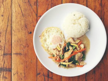 kızarmış tavuk pilav ve kızarmış yumurta ahşap arka plan üzerinde beyaz plaka ile Çin sebze ve pirinç ile heyecan fry. Sebze iyi sağlık yeşil için. Tayland gıda.