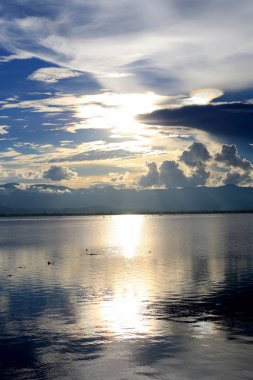 Güzel gün batımı ve dağ ve bulutlar ve Günbatımı ile akşam gökyüzü arka plan için göle yansıyan. Kırsal manzara renkli gökyüzü gün batımında altında şafak Sunrise.