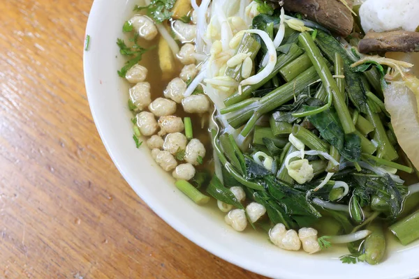 Sopa de fideos vietnamse, servido con hierbas frescas en el restaurante budista, rábano, gloria de la mañana, shiitake y tofu en tazón blanco en la mesa de madera en el Festival Vegetariano . — Foto de Stock