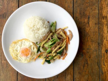 karışık sebze stire kızarmış et ve ahşap arka plan üzerinde beyaz tabak pirinç kızarmış yumurta ile. Tay gıda Sağlık için.