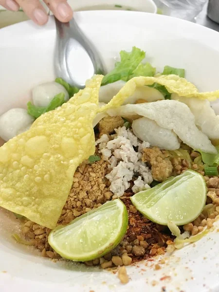 Nouilles thaïlandaises pas de soupe servir avec oeuf, citron et boulette de porc et garnitures épicées. Cuisine de rue thaïlandaise . — Photo