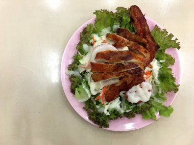 Asya tarzı Sezar salatası ile ızgara tavuk göğsü pembe çanak üzerinde.