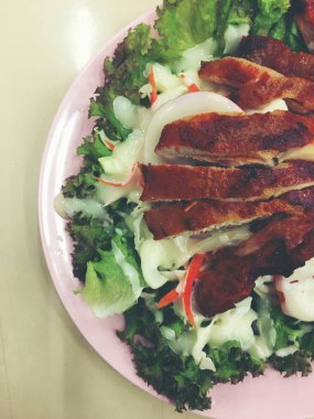 Asya tarzı Sezar salatası ile ızgara tavuk göğsü pembe çanak üzerinde.