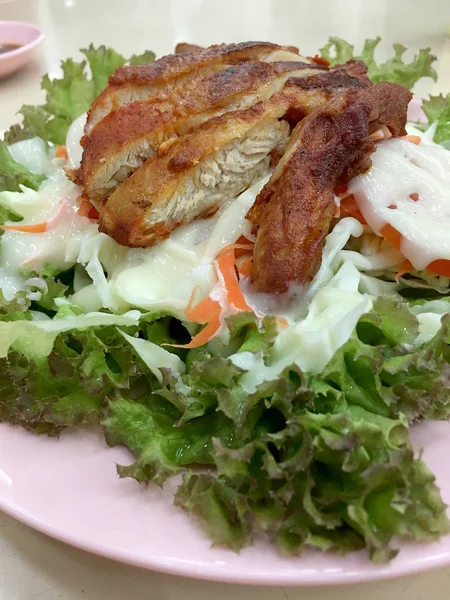 Asya tarzı Sezar salatası ile ızgara tavuk göğsü pembe çanak üzerinde.