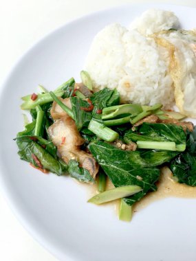 Fry stir Kai arazi ve gevrek domuz eti, beyaz arka plan üzerinde beyaz tabak kızarmış pilav pilav ile karıştırın. Tay tarzında gıda.