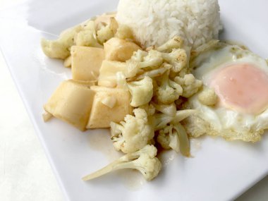 Karıştırın kızarmış Tofu Çin tarzı, derin kızarmış Tofu sosu soslu karnabahar ve Tay tarzında kızarmış yumurta beyaz arka plan üzerinde beyaz plaka ile tofu karıştırın kızarmış. Vejetaryen yiyecekler, sağlıklı gıda.