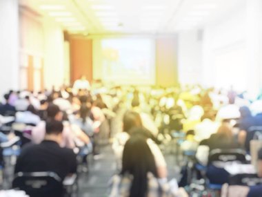 Eğitim kavramı, arka plan bulanık görüntü okuyan öğrenciler ve iş soyut ve büyük salonu meslek seminer ekran ve bilgi göstermek için projektör ile tartışmak.