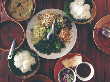 Yerel sebze ile sahip çeşitli pirinç makarna köri ve birçok türden bir ahşap masa ünlü gıda Tayland Tayland pirinç makarna için sos karışık. -Tayland Mutfağı bir dizi. (Tay Kuzey stili).