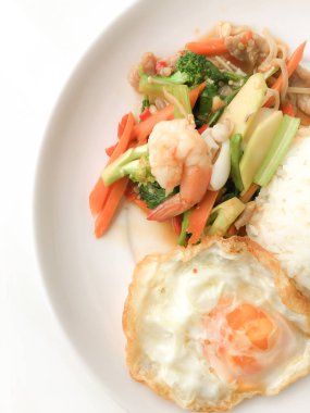 Kızarmış lezzetli shimp ve kızarmış yumurta beyaz arka plan üzerinde beyaz tabak pirinç Tay ev yapımı yemek ya da restoranda yemek tarifi olarak hizmet ile karışık sebze sote. Tay tarzında gıda.