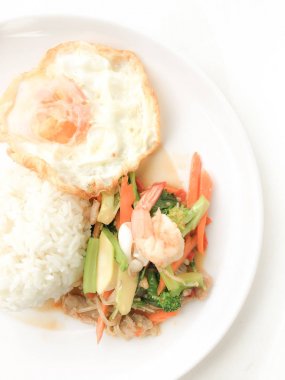 Kızarmış lezzetli shimp ve kızarmış yumurta beyaz arka plan üzerinde beyaz tabak pirinç Tay ev yapımı yemek ya da restoranda yemek tarifi olarak hizmet ile karışık sebze sote. Tay tarzında gıda.