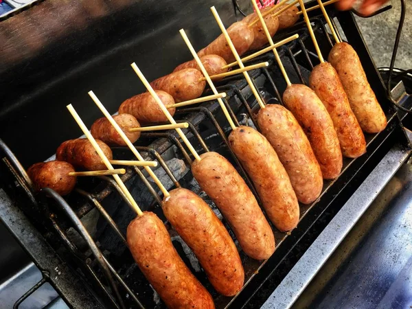 Embutidos fritos con ajo, hierbas y papas fritas en una sartén — Foto de Stock