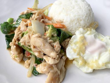 karışık sebze ve pirinç eski ahşap masa üzerinde beyaz tabak içinde Tay tarzında kızarmış yumurta ile tavada kızartılmış tavuk. Asya Tayland gıda.