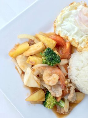 Renkli Fried karıştırın tatlı ve ekşi soslu sebze, karides ve domuz eti, meyve ve sebze beyaz arka plan üzerinde beyaz tabak içinde bir arada. Tay tarzında gıda.