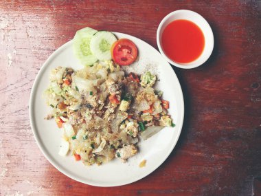 Kızarmış tavuk erişte ve yumurta beyaz tabak ahşap masa üzerinde ilave edin. Tay yemeği. Vintage rengi.