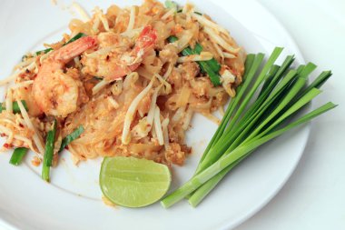 Pad Thai, tavada kızartılmış Pirinç Noodle ile beyaz tabak karides ile slayt limon ve yeşil sebze. Tayland'ın ulusal ana yemek biri. Tayland popüler gıda. Tayland kızarmış noodle