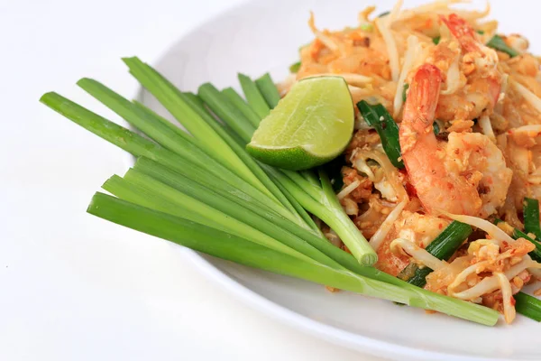 Pad Thai, stir-fried rice noodles with shrimp in white plate with slide lemon and green vegetable. The one of Thailand's national main dish. the popular food in Thailand. Thai Fried Noodles