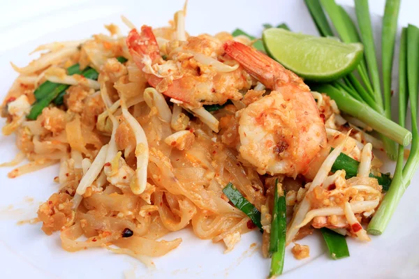 Pad Thai, stir-fried rice noodles with shrimp in white plate with slide lemon and green vegetable. The one of Thailand's national main dish. the popular food in Thailand. Thai Fried Noodles