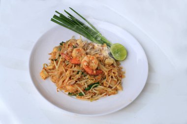 Tay tarzı noodle, tampon Tay, tavada kızartılmış Pirinç Noodle karides ile beyaz arka plan üzerinde beyaz tabakta sebze ile servis yapın. Tayland'ın ulusal ana yemek biri. Tayland popüler gıda.