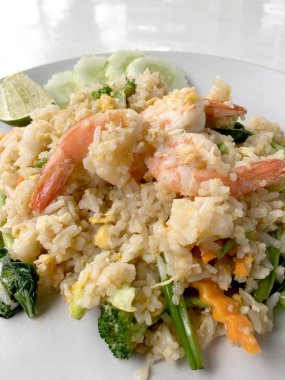 Limon ve beyaz arka plan üzerinde beyaz tabak içinde salatalık Fried rice karides otlar ve sebze ile servis. Dokuz Asya gıda yemekler bir dizi parçası. Tayland gıda.