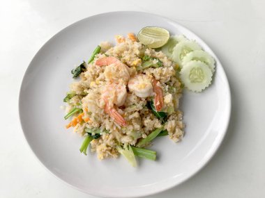 Limon ve beyaz arka plan üzerinde beyaz tabak içinde salatalık Fried rice karides otlar ve sebze ile servis. Dokuz Asya gıda yemekler bir dizi parçası. Tayland gıda.