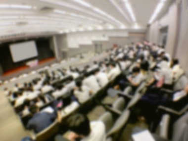 Eğitim kavramı, arka plan bulanık görüntü okuyan öğrenciler ve iş soyut ve büyük salonu meslek seminer ekran ve bilgi göstermek için projektör ile tartışmak.