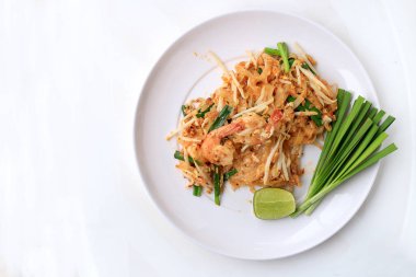 Pad Thai, tavada kızartılmış Pirinç Noodle ile beyaz tabak karides ile slayt limon ve yeşil sebze. Tayland'ın ulusal ana yemek biri. Tayland popüler gıda. Tayland kızarmış noodle