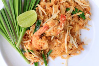 Pad Thai, tavada kızartılmış Pirinç Noodle ile beyaz tabak karides ile slayt limon ve yeşil sebze. Tayland'ın ulusal ana yemek biri. Tayland popüler gıda. Tayland kızarmış noodle