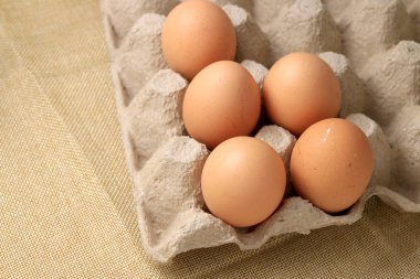 Taze tavuk yumurta 30 kağıt kutu ve krem kumaş arka plan üzerinde yumurta için boş alana sahip.