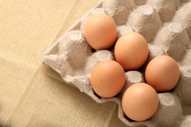 Taze tavuk yumurta 30 kağıt kutu ve krem kumaş arka plan üzerinde yumurta için boş alana sahip.