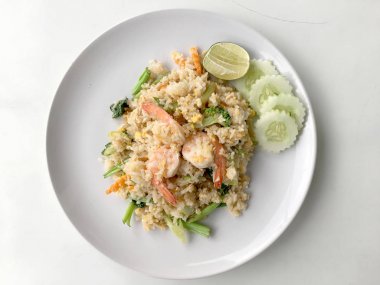 Limon ve beyaz arka plan üzerinde beyaz tabak içinde salatalık Fried rice karides otlar ve sebze ile servis. Dokuz Asya gıda yemekler bir dizi parçası. Tayland gıda.
