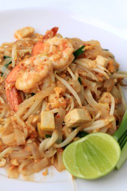 Tay tarzı noodle, tampon Tay, tavada kızartılmış Pirinç Noodle karides ile beyaz arka plan üzerinde beyaz tabakta sebze ile servis yapın. Tayland'ın ulusal ana yemek biri. Tayland popüler gıda.
