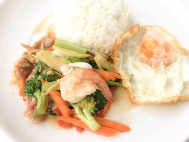 Kızarmış lezzetli shimp ve kızarmış yumurta beyaz arka plan üzerinde beyaz tabak pirinç Tay ev yapımı yemek ya da restoranda yemek tarifi olarak hizmet ile karışık sebze sote. Tay tarzında gıda.