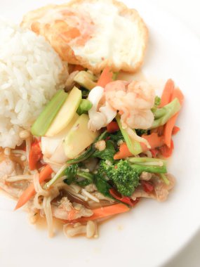 Kızarmış lezzetli shimp ve kızarmış yumurta beyaz arka plan üzerinde beyaz tabak pirinç Tay ev yapımı yemek ya da restoranda yemek tarifi olarak hizmet ile karışık sebze sote. Tay tarzında gıda.