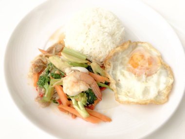 Kızarmış lezzetli shimp ve kızarmış yumurta beyaz arka plan üzerinde beyaz tabak pirinç Tay ev yapımı yemek ya da restoranda yemek tarifi olarak hizmet ile karışık sebze sote. Tay tarzında gıda.