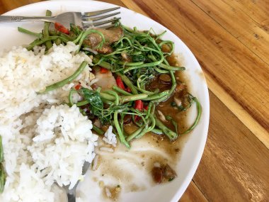 Kızarmış Su Minosa, beyaz tabakta kızarmış domuz eti, pilav ve ahşap masada kızarmış yumurta. Tayland tarzı yemek..