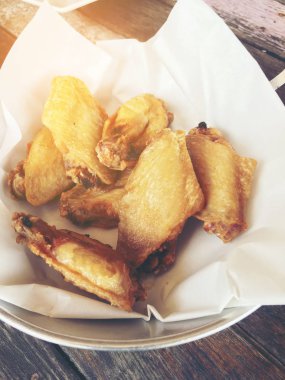 Kovada sarımsak soslu kızarmış tavuk kanadı. Asyalı yemek konsepti için ahşap masada. Tayland tarzı yemek..