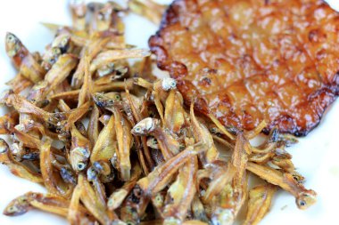 Kızarmış dev yayın balığı ve kızartılmış küçük balıklar (Minnow) geleneksel Tayland tarifleri kırsal ahşap arka planda beyaz tabakta. Tayland 'da popüler, Tayland' ın önemli ihracat ürünü.