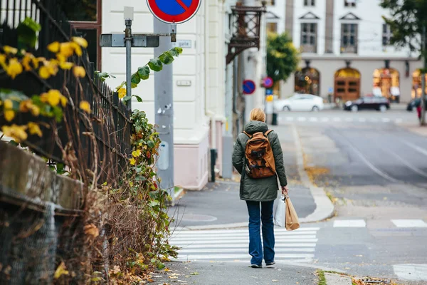 Mujer con mochila caminando por la calle —  Fotos de Stock