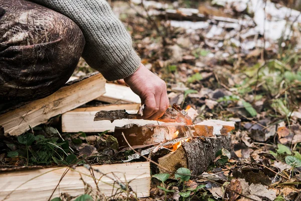 El hombre enciende fuego en el bosque —  Fotos de Stock