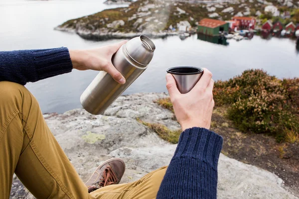 Homme buvant du thé dans un thermos au sommet d'une colline — Photo
