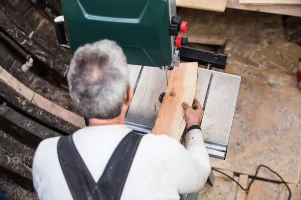 Man grinds wooden log — Stock Image Man grinds wooden log Royalty Free Stock Images