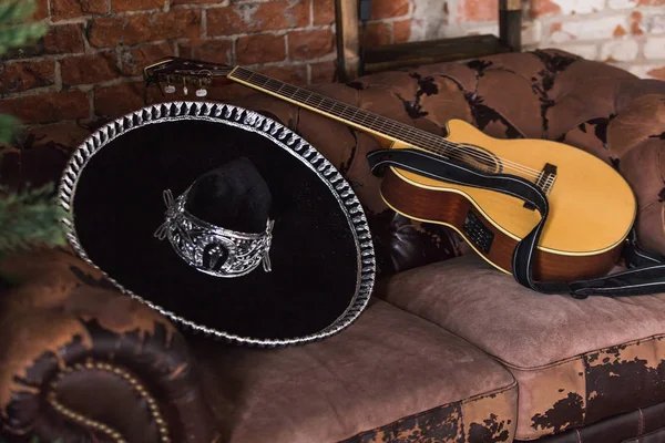 Sombrero chapéu e guitarra no sofá — Fotografia de Stock