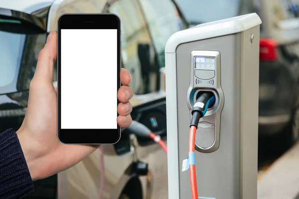 Hand with phone on a background of electric cars — Stock Photo, Image