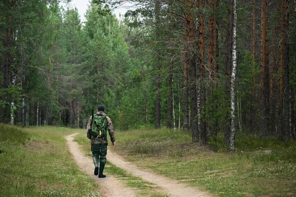 Erkek avcı bir orman yolda gider — Stok fotoğraf