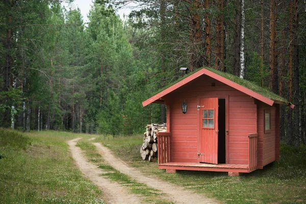 Rode houten jachthuis met gras — Stockfoto